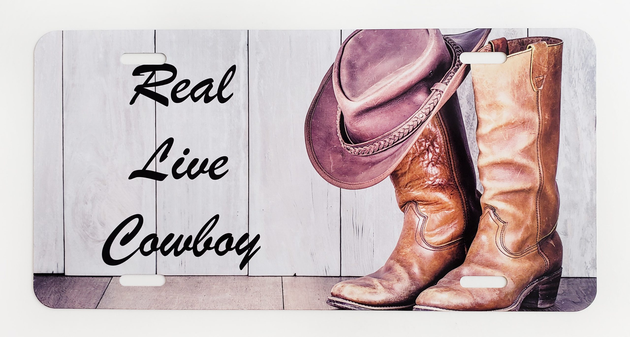 A cowboy boot and hat sitting on top of a wooden fence.