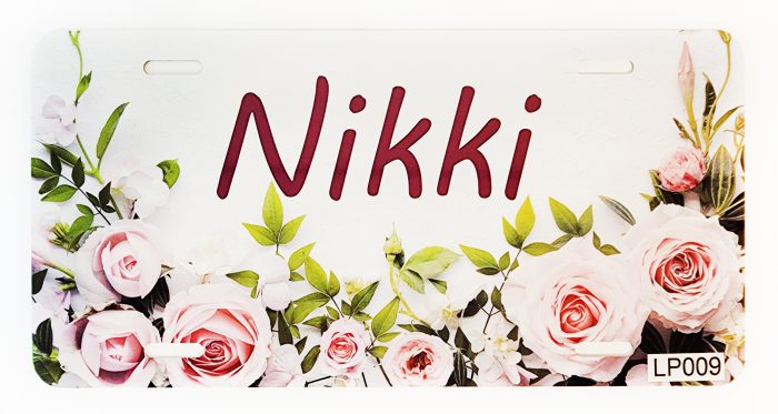 A close up of the name nikki in front of pink roses.