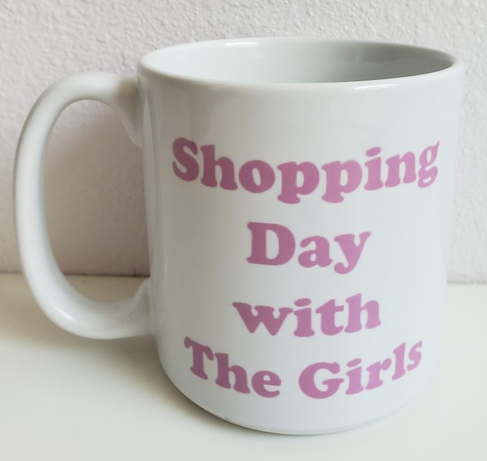 A white coffee mug with the words " shopping day with the girls ".