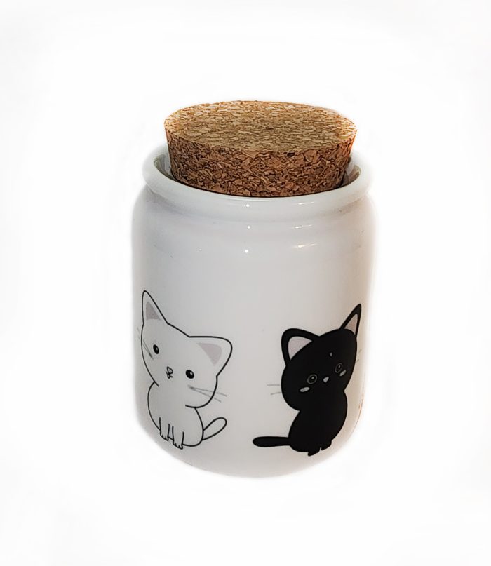 A white jar with black and white cats on it