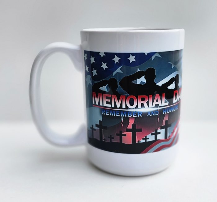 A mug that says memorial day with an american flag and cross.