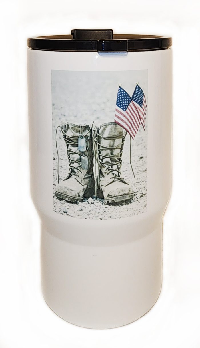 A close up of the boots on the ground with an american flag.