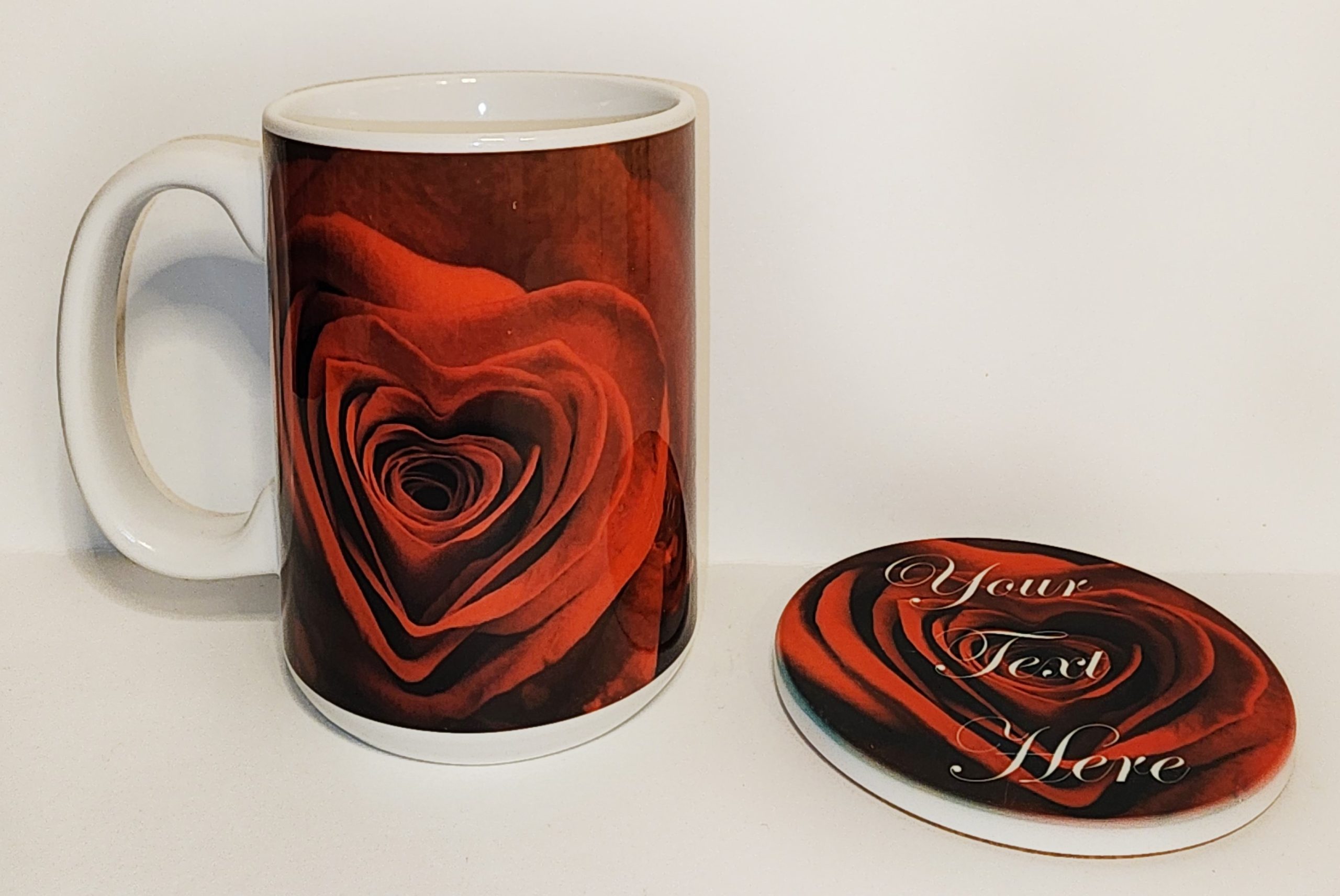 A coffee mug and coaster with the image of a heart.